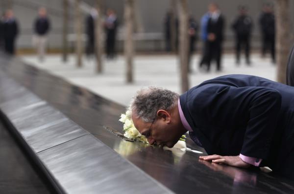 Charles Wolf kisses the name of his wife Katherine Wolf, a British citizen who died at Ground Zero during the 9/11 attacks at the World Trade Center Memorial on March 15, 2012 in New York, New York